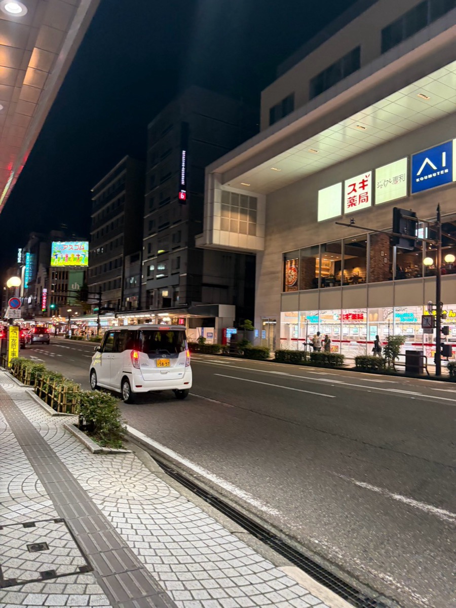 夜の片町大通り沿い。バス通りに面した商業ビルと店舗の明かり