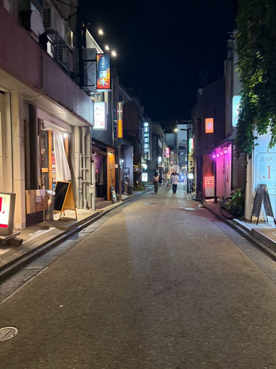 夜の片町の飲み屋小路。両側にBARや割烹の看板が並ぶ細い通り